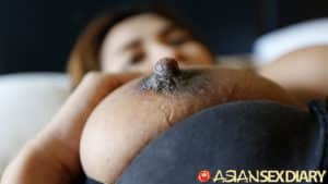 Closeup of big dark nipples towering above large mound of boobs