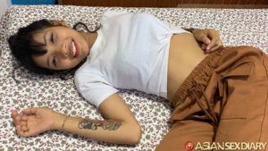 Cute smile tatted Asian on bed