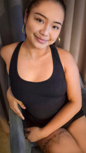 Smiling Bella in black top on chair
